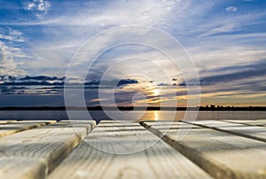 Wooden board empty table in front of sunset sea & sky background. Perspective wood floor over sea and sunset sky & summer concepts