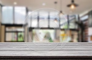 Wooden board empty Table Top And Blur Interior over blur in coffee shop Background, Mock up for display of product