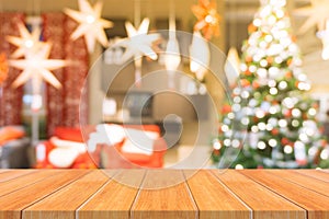 Wooden board empty table top on of blurred background. Perspective brown wood table over blur christmas tree background.