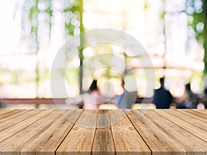 Wooden board empty table top on of blurred background. Perspective brown wood table over blur in coffee shop background.