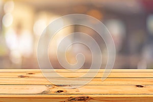 Wooden board empty table top on of blurred background. Perspective brown wood table over blur in coffee shop background.