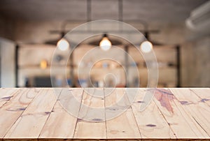 Wooden board empty table top on of blurred background. Perspective brown wood table over blur in coffee shop background - can be u