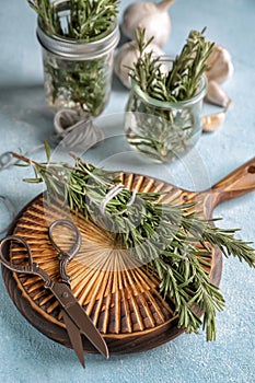 Wooden board with fresh rosemary on table