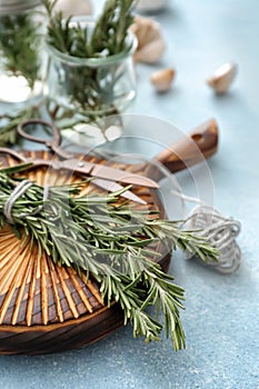 Wooden board with fresh rosemary on table