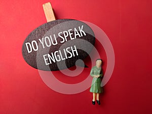 Wooden board and miniature people with the word DO YOU SPEAK ENGLISH
