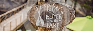 Wooden board with a motivational phrase. Life better at the lake. Inspiration quote BANNER, LONG FORMAT