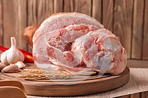 Wooden board with raw pork leg on table. Fresh meat products