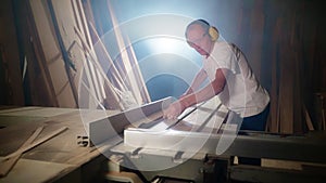 Wooden board rip cuts with a table saw. Carpenter at work