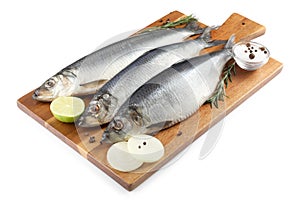 Wooden board with salted herrings, onion, lime, spices and rosemary isolated on white