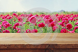 wooden board table in front of summer flowers field