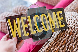 Wooden board with text welcome in man hand. Bali island. Welcome sign.