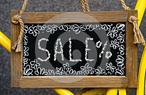 wooden board with word sale written with chalk, signboard. symbol of information, business, marketing and selling