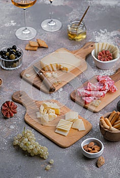 Wooden boards full of delisious appetizers cheese, salumi, grapes, honey and nuts
