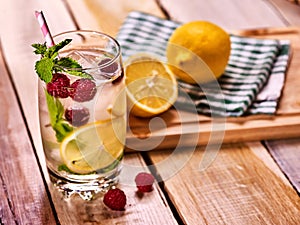 Wooden boards is glasses with raspberry mojito and cubes ice.