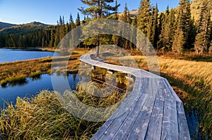 Wooden boardwalk along the lake in the mountains