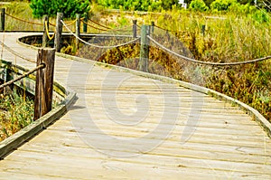 Wooden boardwalk in the dunes leading to the sandy beach, the pa