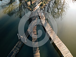 Wooden boardwalk on lake, drone shot.