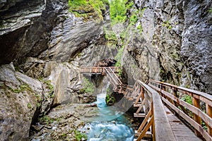 Wooden boardwalk leads through a tight canyon over whitewater, S