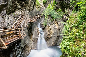 Wooden boardwalk leads through a tight canyon over whitewater, S