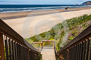 Wooden Boardwalk, Staircase Leading to Pacific ocean. Wooden staircase leading down to a beach in a sunny summer day