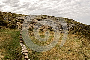 Wooden boardwalk steps on a hiking track leading to top of Mastravarden hill on Mosteroy island