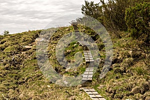 Wooden boardwalk steps on a hiking track to Mastravarden at Mosteroy island