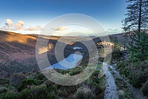 Wooden boardwalk on the top of a mountain with scenic view on Glendalough lakes in Wicklow Mountains