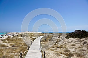 Wooden boardwalk and turquoise water at the Illetes beach in Formentera. Balearic Islands. Spain