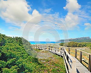 Wooden boardwalk under a cloudy sky in Capo Testa