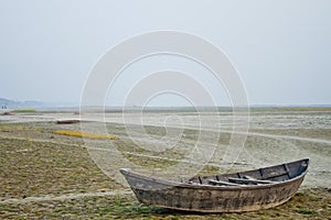 A wooden boat on the bank of the dry river at Dhaka, Bangladesh