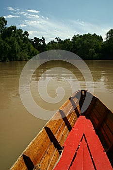 Wooden boat on brown river