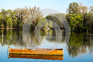 Wooden boat in the calm lake water on a spring day