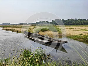 a wooden boat damped on the river side