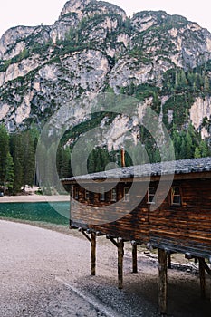 Wooden boat dock hut on the Lago di Braies on the background of rocky mountains and forests. Braies lake in the