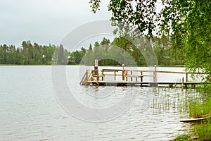 Wooden boat dock on lake. Purhon Campsite, Hamina, Finland, Suomi photo