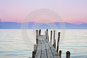 Wooden boat dock with the sunset sky on the background in Lake Atitlan, Guatemala photo