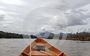 Wooden boat front and green jungle landscape, sailing in the muddy water of the Beni river, Amazonian rainforest, Bolivia