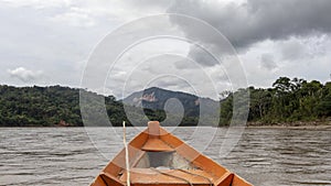 Wooden boat front and green jungle landscape, sailing in the muddy water of the Beni river, Amazonian rainforest, Bolivia