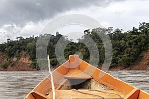 Wooden boat front and green jungle landscape, sailing in the muddy water of the Beni river, Amazonian rainforest, Bolivia photo