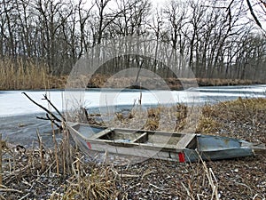 Wooden boat by the frozen winter river