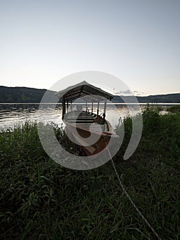 Wooden boat on green grass wetland shore of Sauce Lagoon lake Tarapoto Amazon river jungle rainforest Peru South America