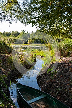 Wooden boat moored in the bay of the river among the reeds