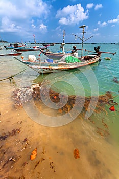 The wooden boat with the motor in sea water