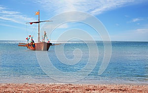 A wooden boat with oars floats on the sea