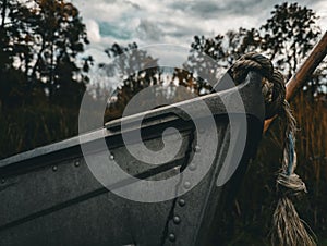 Wooden boat tied to a tree with a rope alongside grassy path in a forest, Hamilton, Ontario, Canada