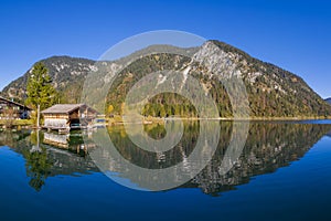 Wooden boathouse next scotch pine at wonderful reflecting lake plansee