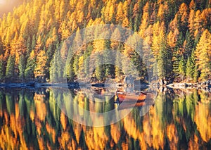 Wooden boats on Braies lake at sunrise in autumn