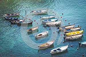 Wooden boats moored in the middle of the sea. Small port of fishing boats. Intense blue sea. Different colors