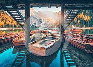 Wooden boats near the house in Braies lake at sunrise