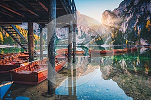 Wooden boats near the house in Braies lake at sunrise